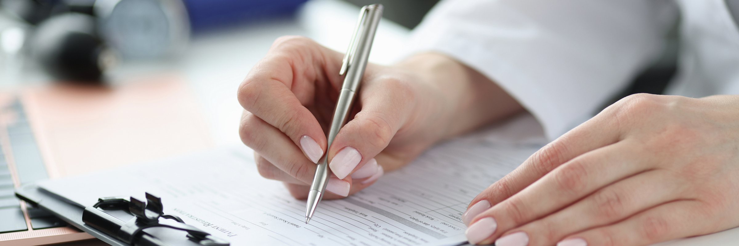 Doctor Filling Out Patients Medical History in Office Closeup